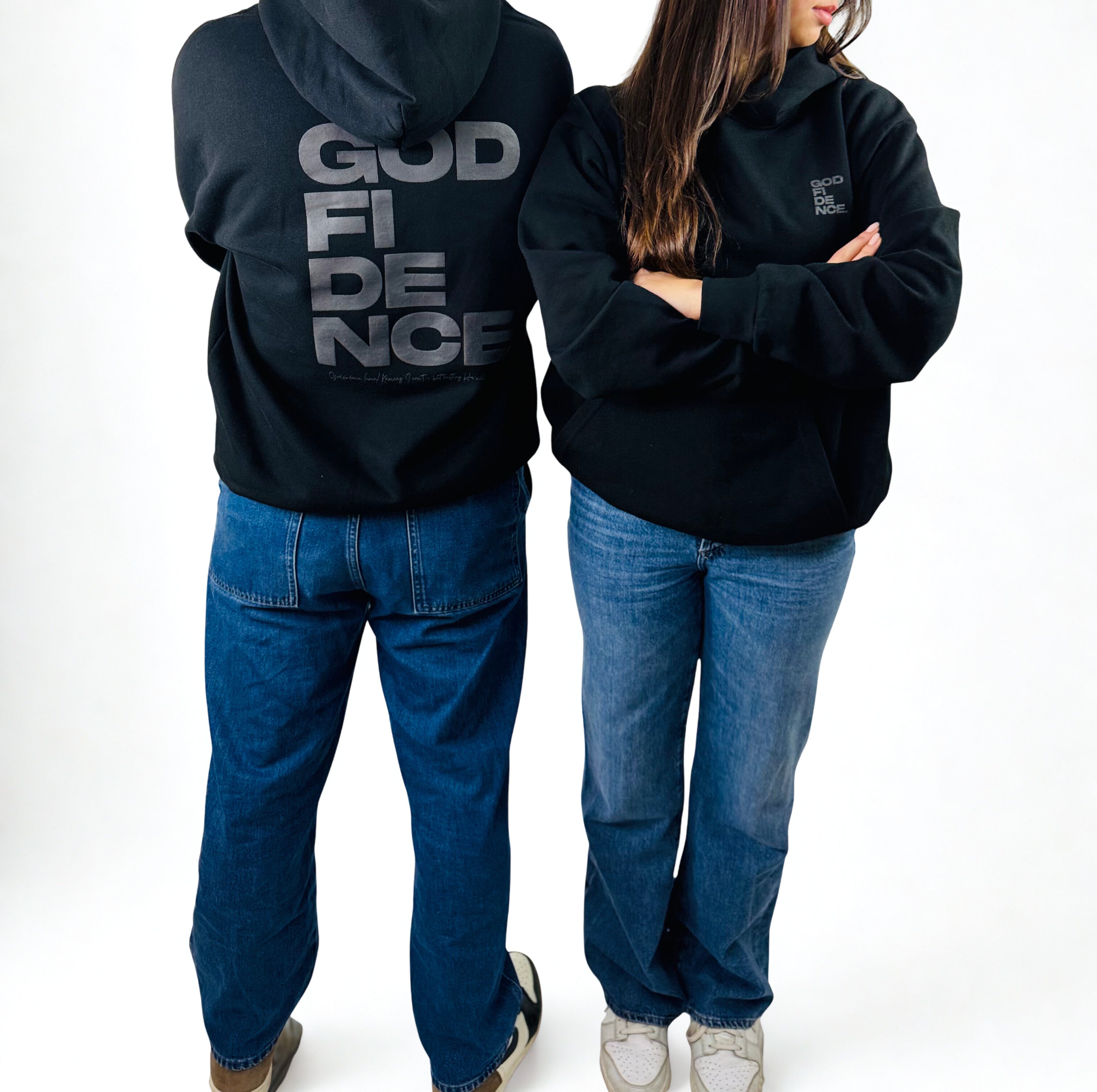 Two people wearing black hoodies with text, one with 'GOD FIDENCE' on the back.