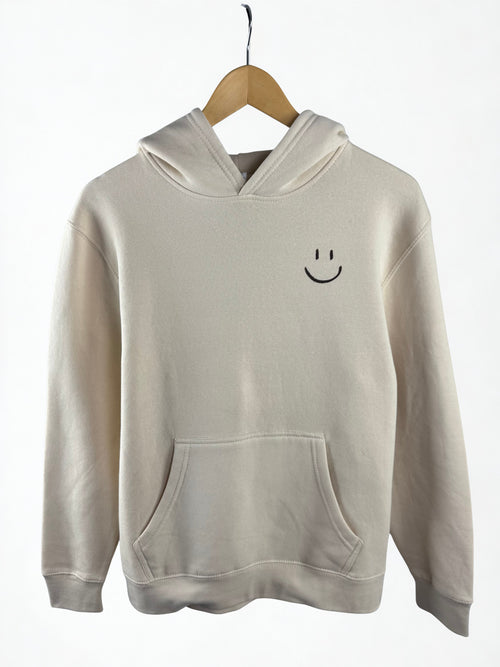 Cream  hoodie with a smiley face pocket  emblem on a cream background
