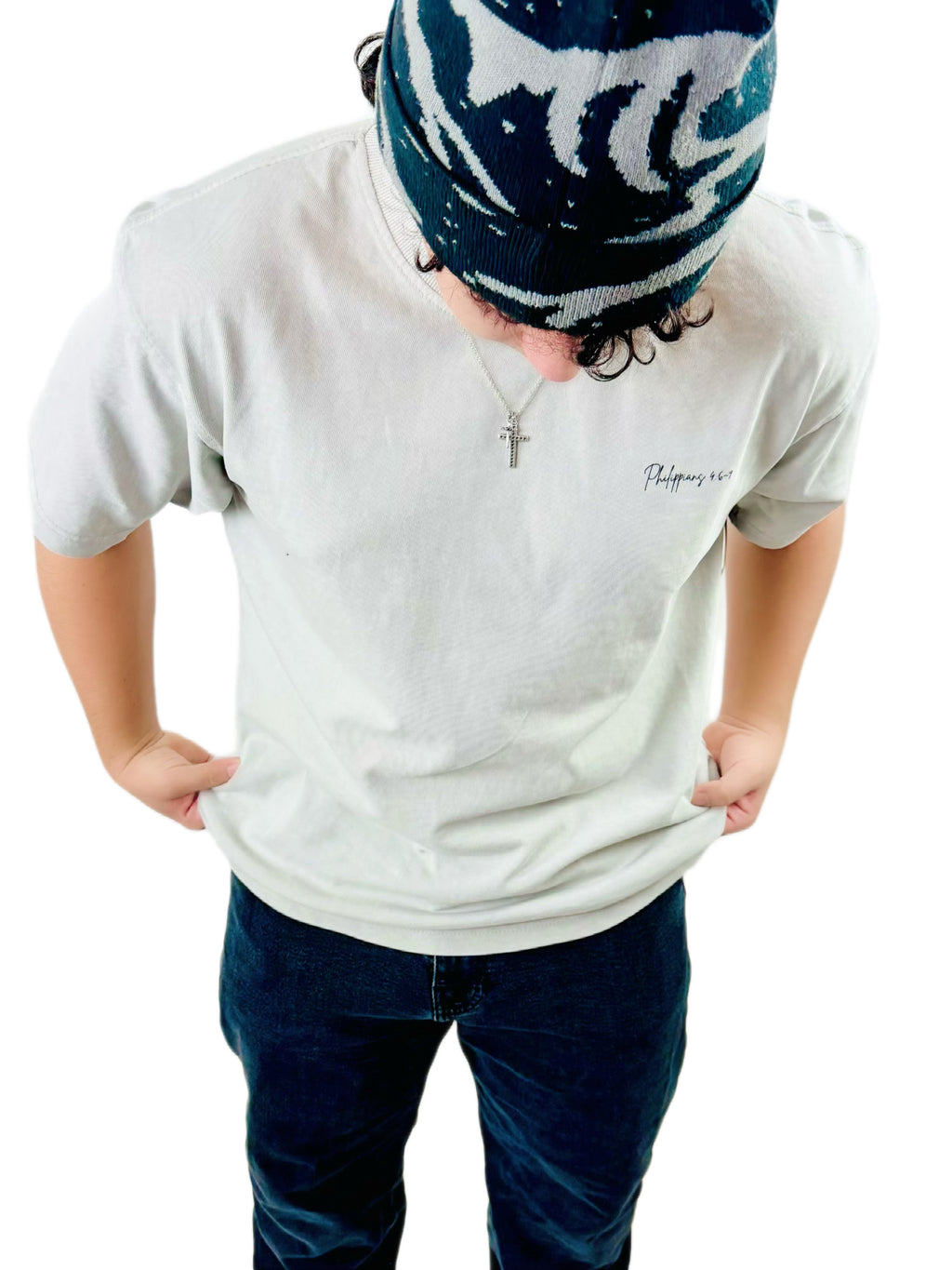 Person wearing a bone  t-shirt with the word Philippians small script on a white background